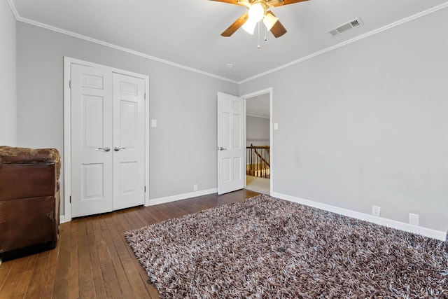 bedroom with dark wood-type flooring, ceiling fan, and ornamental molding