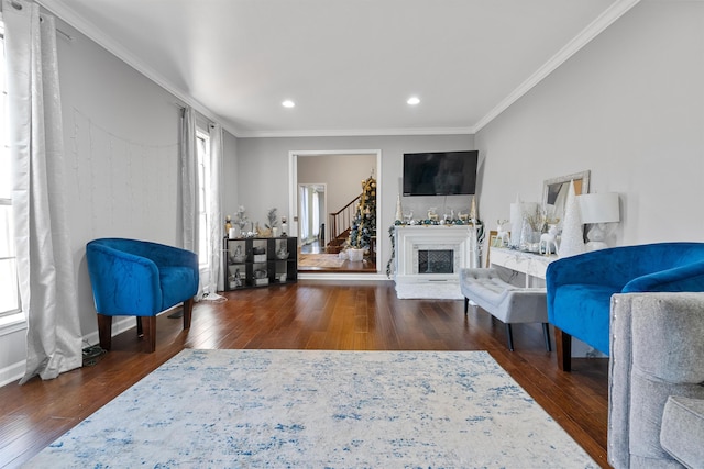 living room with crown molding, plenty of natural light, and dark hardwood / wood-style floors