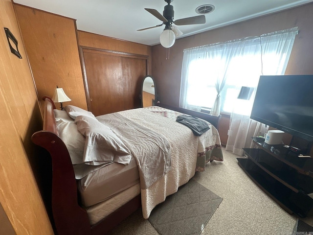 carpeted bedroom with ceiling fan and a closet