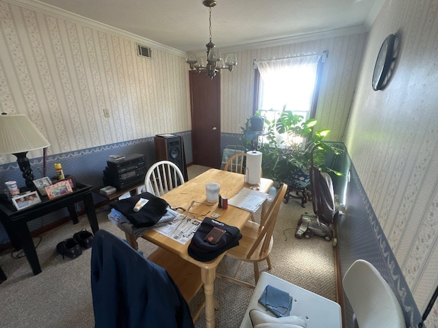 dining room featuring crown molding, carpet floors, and a notable chandelier