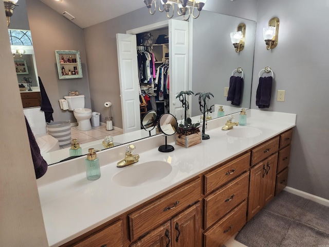 bathroom with vanity, lofted ceiling, tile patterned floors, and toilet