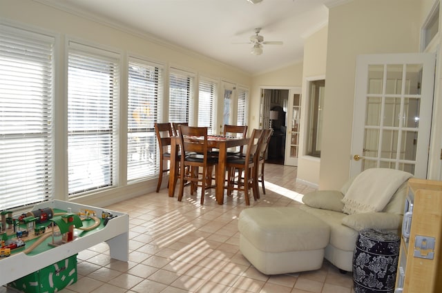 tiled dining space with lofted ceiling, ornamental molding, and ceiling fan