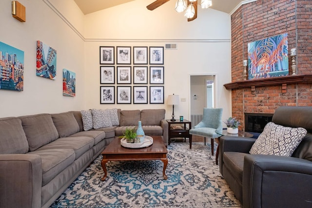 living room with a fireplace, high vaulted ceiling, and ceiling fan