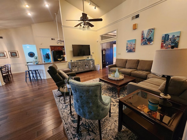 living room with ceiling fan, rail lighting, dark hardwood / wood-style floors, and high vaulted ceiling