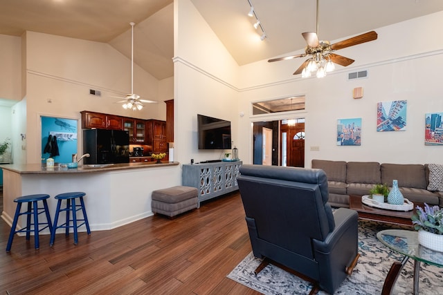 living room with ceiling fan, dark hardwood / wood-style flooring, high vaulted ceiling, and rail lighting