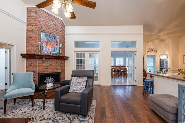 living room with lofted ceiling, sink, ceiling fan, dark hardwood / wood-style floors, and a fireplace