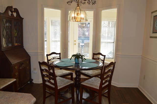 dining space with a notable chandelier and dark hardwood / wood-style flooring