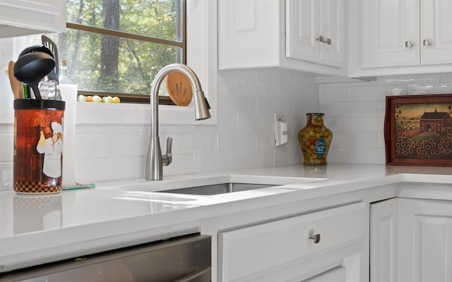 kitchen with white cabinetry, sink, tasteful backsplash, and dishwasher