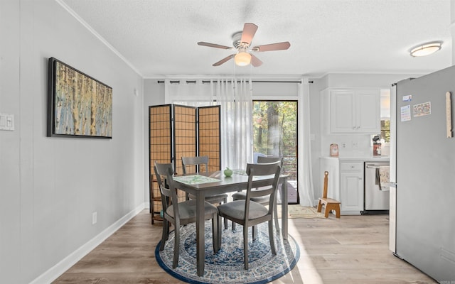 dining area with crown molding, ceiling fan, light hardwood / wood-style floors, and a textured ceiling