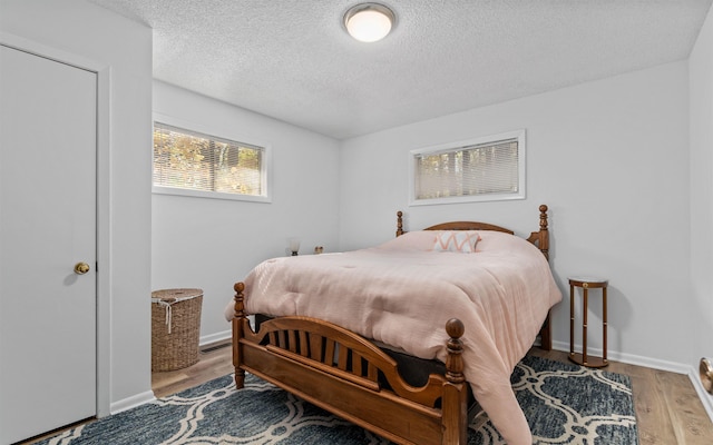 bedroom with hardwood / wood-style floors and a textured ceiling