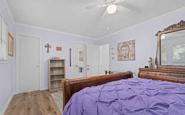 bedroom featuring ceiling fan, crown molding, a textured ceiling, and light wood-type flooring