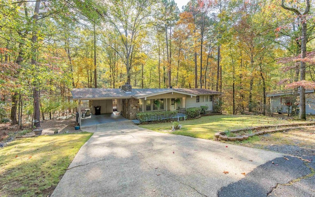 view of front of property with a carport and a front lawn