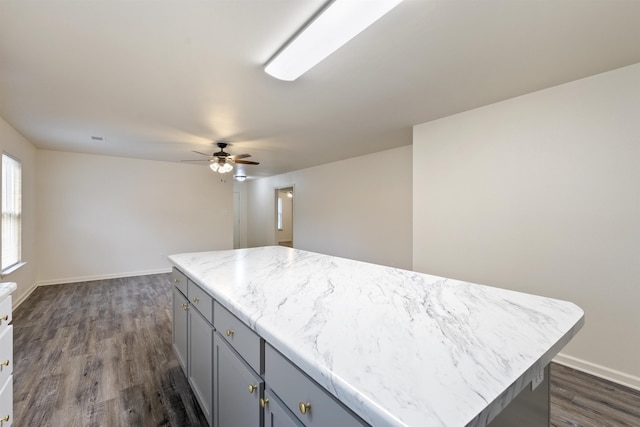 kitchen featuring a center island, dark wood-type flooring, ceiling fan, and gray cabinetry