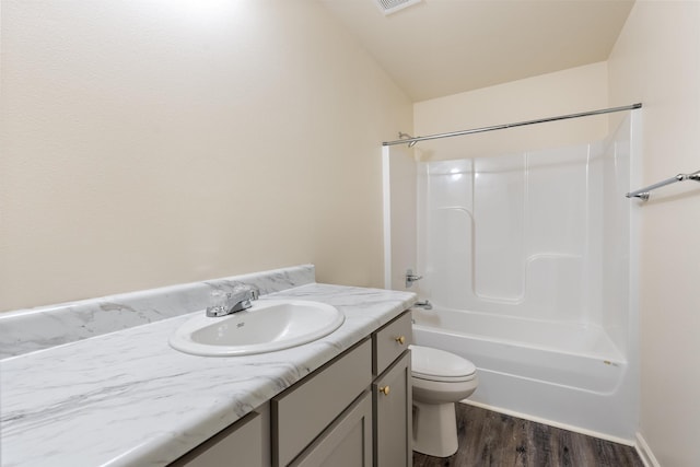 full bathroom featuring toilet, wood-type flooring, vaulted ceiling, vanity, and shower / bath combination