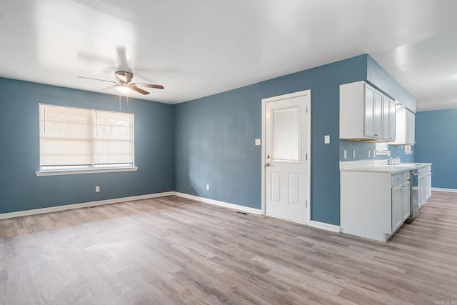 interior space with sink, dishwasher, ceiling fan, light hardwood / wood-style floors, and white cabinets