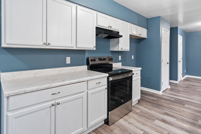 kitchen featuring electric stove, light stone counters, white cabinets, and light wood-type flooring