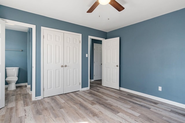 unfurnished bedroom featuring ensuite bath, light hardwood / wood-style floors, a closet, and ceiling fan