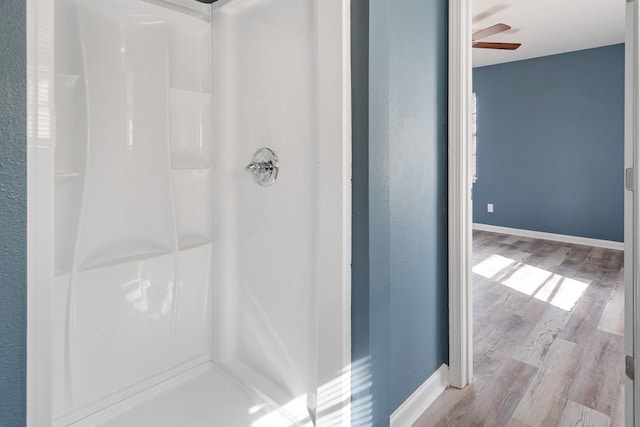 bathroom featuring walk in shower, ceiling fan, and hardwood / wood-style floors