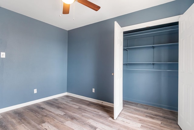 unfurnished bedroom featuring hardwood / wood-style floors, ceiling fan, and a closet