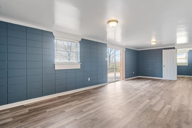 spare room with hardwood / wood-style flooring and tile walls