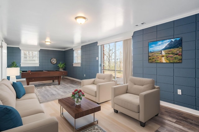 living room featuring wood-type flooring and tile walls