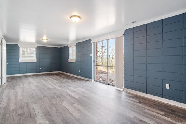 unfurnished room featuring tile walls and light wood-type flooring