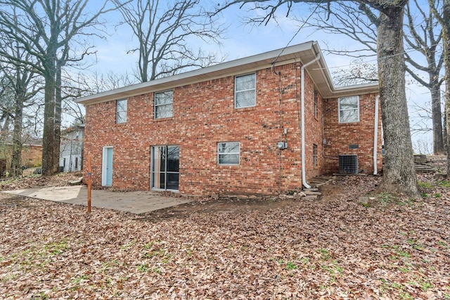 back of property with central AC unit and a patio