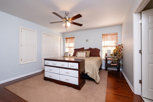 bedroom with multiple windows, dark wood-type flooring, a closet, and ceiling fan