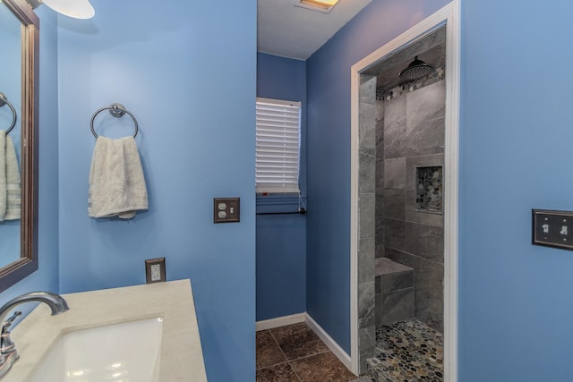 bathroom with vanity and a tile shower