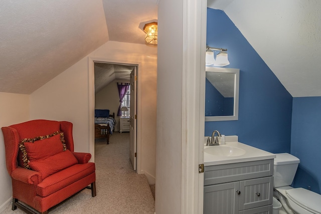 bathroom featuring vanity, vaulted ceiling, and toilet