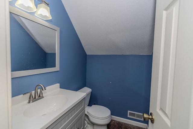 bathroom featuring lofted ceiling, vanity, and toilet