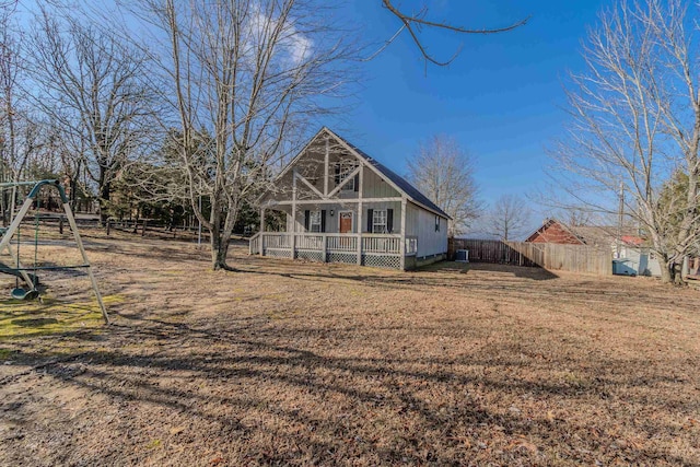 back of house featuring a playground and a lawn