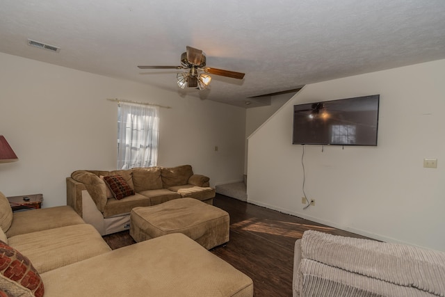 living room with ceiling fan, a textured ceiling, and dark hardwood / wood-style flooring