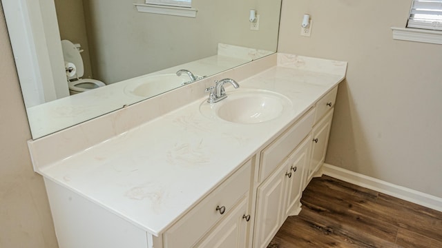 bathroom with vanity, wood-type flooring, and toilet