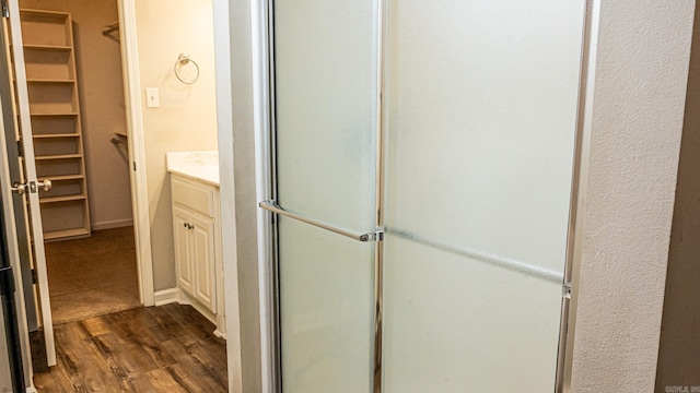 bathroom with a shower with door, vanity, and hardwood / wood-style floors