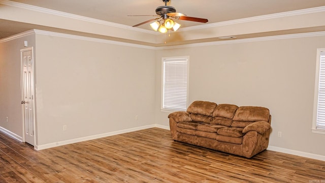 living area featuring hardwood / wood-style flooring, ornamental molding, and ceiling fan