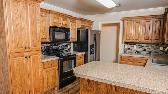 kitchen featuring crown molding, black appliances, kitchen peninsula, and decorative backsplash