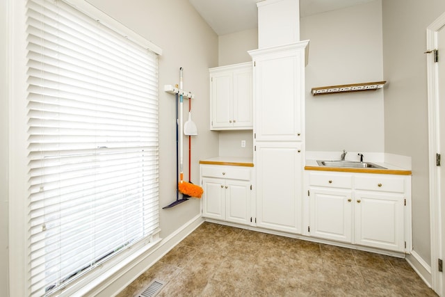 kitchen featuring white cabinetry, sink, and a healthy amount of sunlight