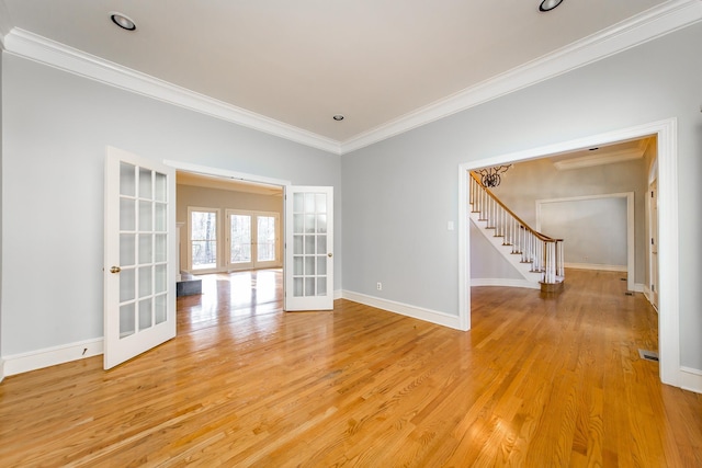 spare room featuring french doors, ornamental molding, and light hardwood / wood-style floors