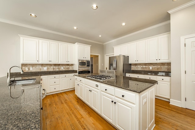 kitchen featuring white cabinetry, sink, a center island, light hardwood / wood-style floors, and stainless steel appliances