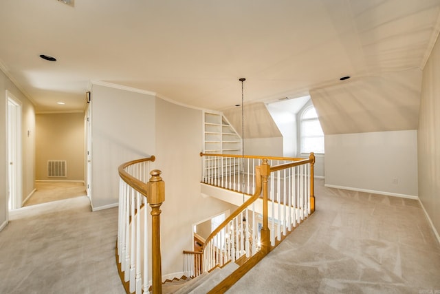 corridor featuring light carpet, crown molding, and vaulted ceiling