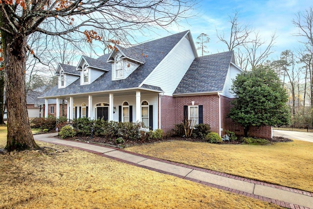 cape cod house with covered porch and a front lawn