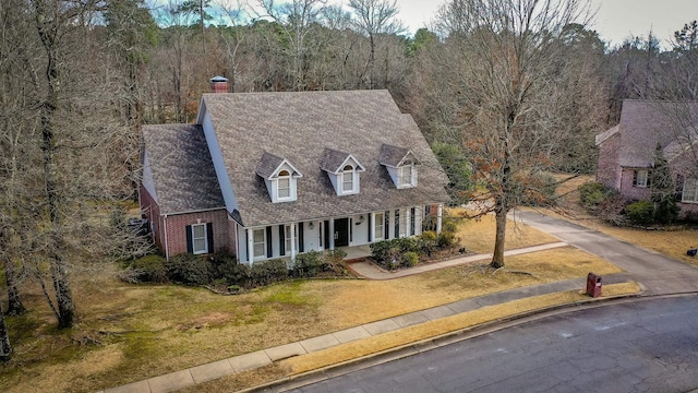 cape cod home featuring a front lawn