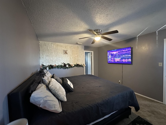 bedroom with ceiling fan, carpet flooring, and a textured ceiling