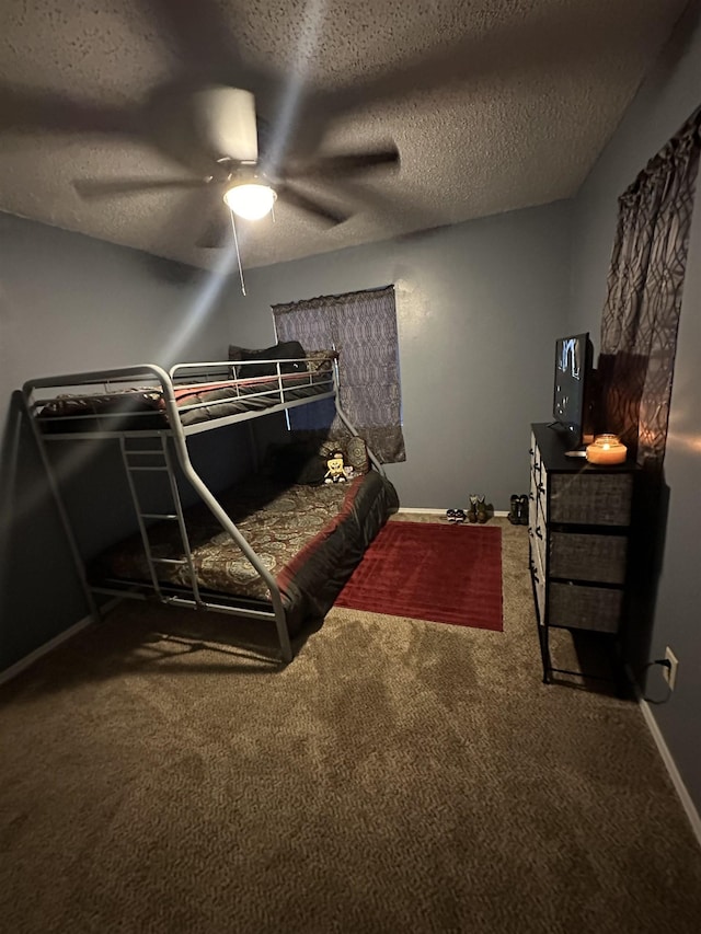 bedroom featuring ceiling fan, carpet floors, and a textured ceiling