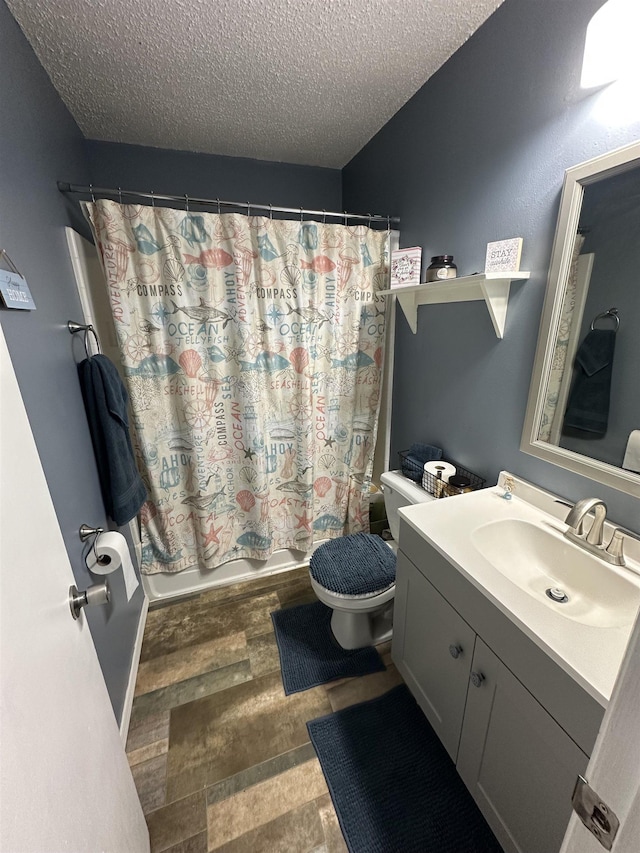 full bathroom with shower / bath combo, vanity, a textured ceiling, and toilet