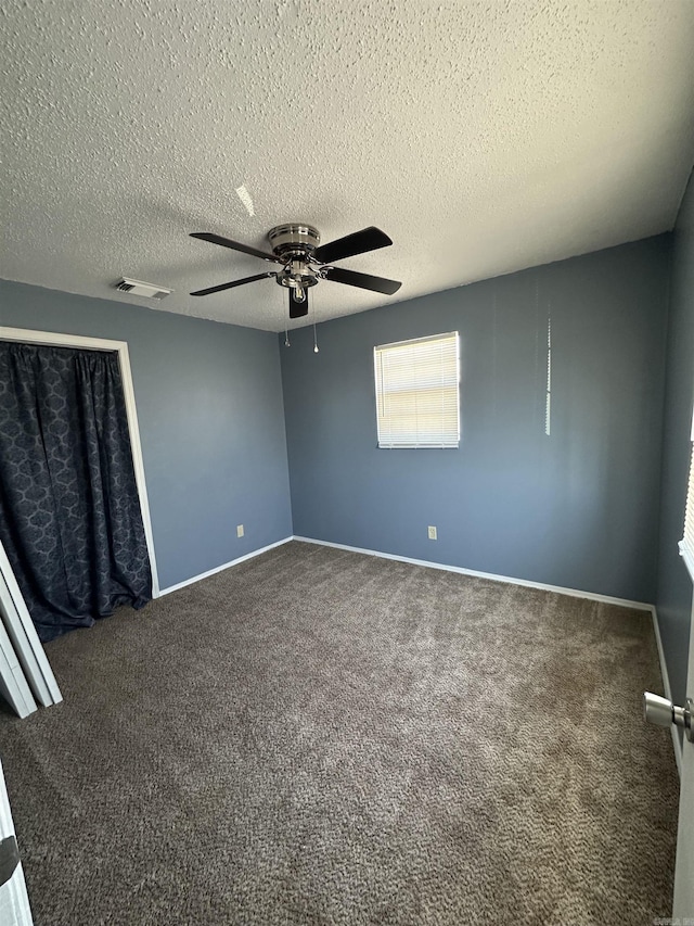 empty room featuring carpet flooring, a textured ceiling, and ceiling fan