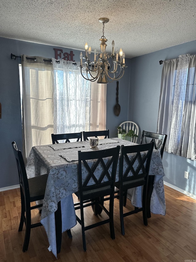 dining room with hardwood / wood-style flooring, a chandelier, and a textured ceiling