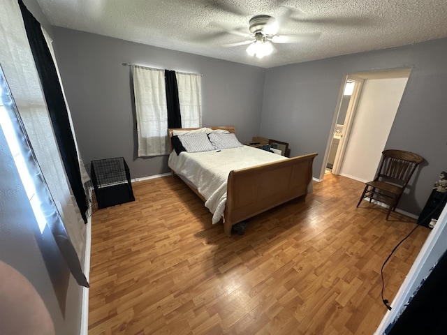 bedroom featuring ceiling fan, light hardwood / wood-style flooring, and a textured ceiling