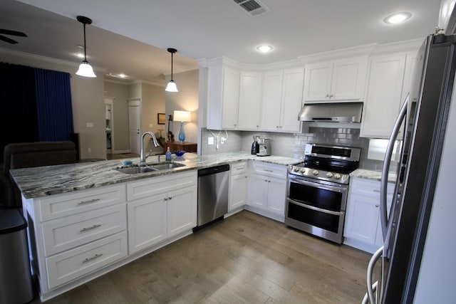 kitchen featuring appliances with stainless steel finishes, white cabinetry, sink, hanging light fixtures, and kitchen peninsula